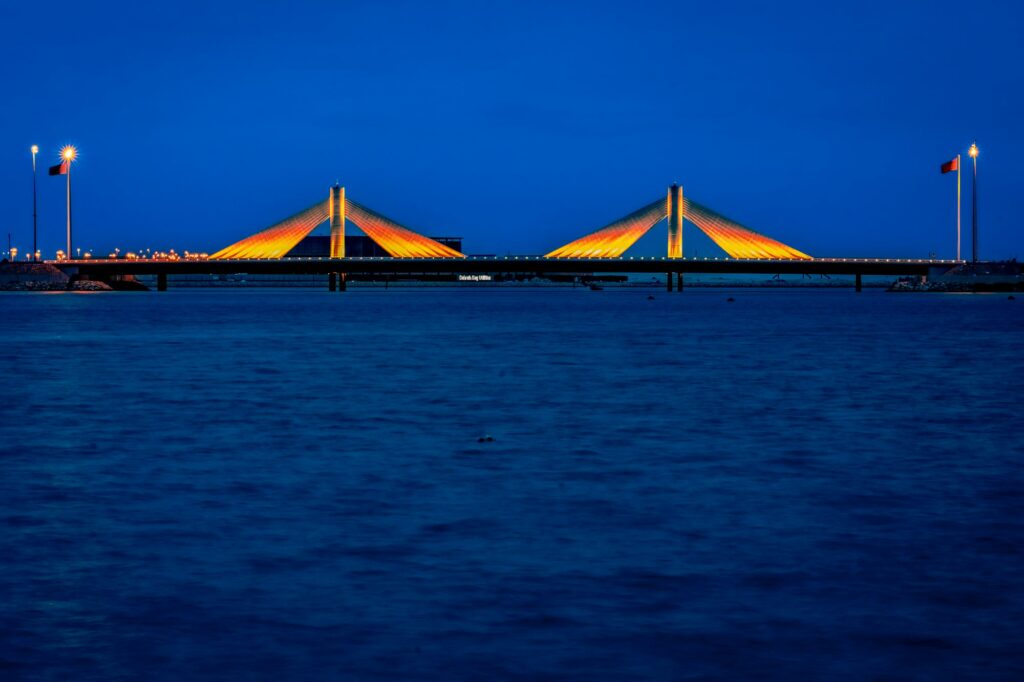 Shaikh Isa bin Salman Causeway Bridge illuminated by lights in the evening Manama, Bahrain