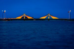 Shaikh Isa bin Salman Causeway Bridge illuminated by lights in the evening Manama, Bahrain